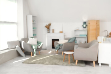 Blurred view of living room with armchairs and fireplace