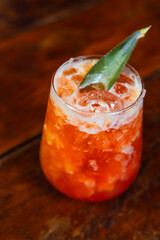 Delicious orange cocktail with pineapple leaf garnish, perfect for a summer day.