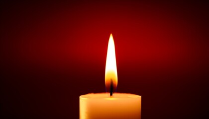 single lit candle on a dark red background warm glowing flame providing light in a solemn or spiritual setting
