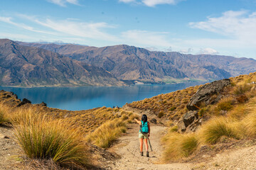 Rear view of hiker enjoying the  views of lake Hawea from the Isthmus track walkway
