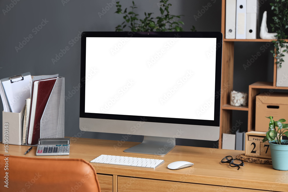 Wall mural blank computer monitor with documents on table in office