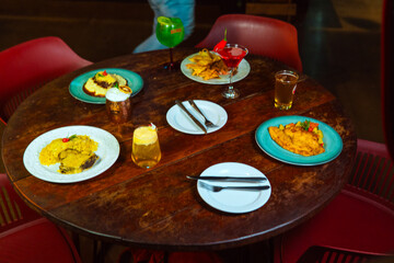 A wooden table set with several delicious dishes and drinks ready for dining.