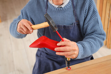 Male shoemaker repairing heel in workshop, closeup