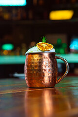 A refreshing cocktail in a copper mug, garnished and ready to be enjoyed at the bar.