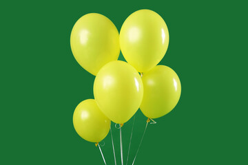 Yellow floating balloons on green background