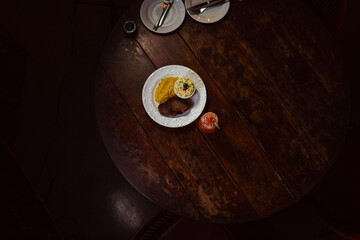 Delicious steak meal and cocktail are displayed on a rustic wooden table in a restaurant.