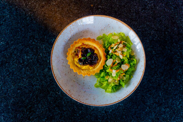 A beautifully presented savory quiche with a fresh side salad, ready to be enjoyed.