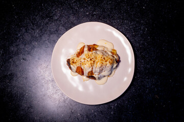 The beautifully plated gourmet dish features a creamy sauce, inviting the viewer with its visual appeal.