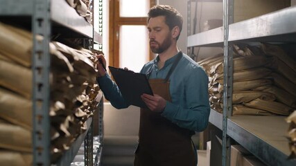 Caucasian man male guy clipboard inventory inspection coffee warehouse packaging shelf factory storage entrepreneur control beans caffeine small business product workplace beverage supply manufacture - Powered by Adobe