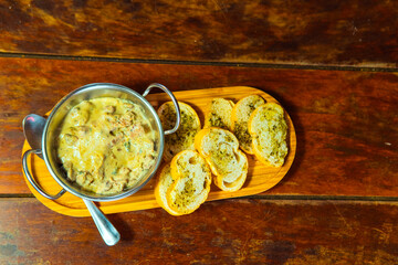 Delicious appetizer served with toasted garlic bread on a wooden platter.