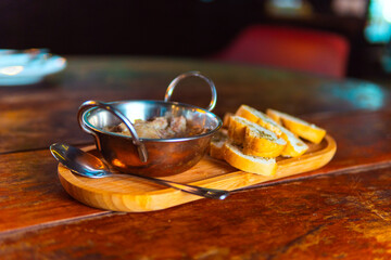 Delicious  served with sliced bread on a rustic wooden board.