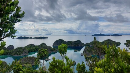 Tropical islands in blue sea under cloudy sky