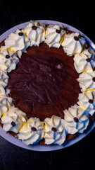 A decadent chocolate cake, adorned with creamy whipped cream and coffee beans, ready to be enjoyed.