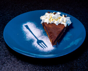 A delicious slice of chocolate cake with whipped cream and a unique design.