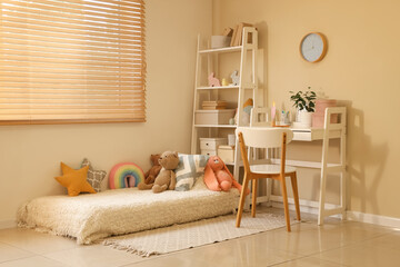 Interior of cozy children's room with shelving unit, workplace and many toys on bed