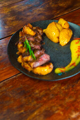 Succulent steak with roasted potatoes and vibrant sauce, a delightful meal.