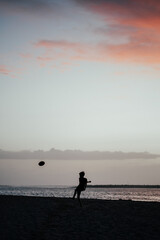 Boy on th Karamea Beach, West Coast, New Zealand at sunset