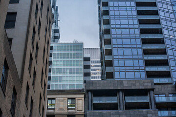 downtown Montreal, quebec canada with mixed era office towers, contrasting modern glass skyscrapers with older stone buildings, illustrating the city's evolving business skyline and economic vitality.