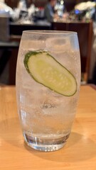 Vertical image of a refreshing glass filled with bubbling gin and tonic served with a slice of...