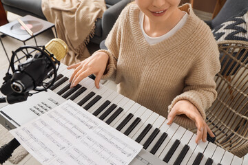 Young woman with microphone playing synthesizer at home, closeup