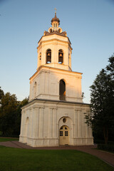 Beautiful old bell architecture building from white marble on nature bright sunny sunset light and blue sky background in the summer park on the hill