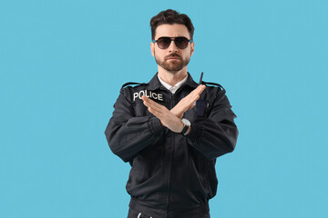Male police officer showing STOP gesture on blue background