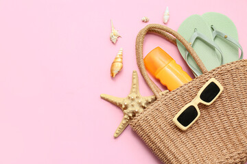 Composition with starfish, seashells, bottle of sunscreen cream and beach accessories on pink...