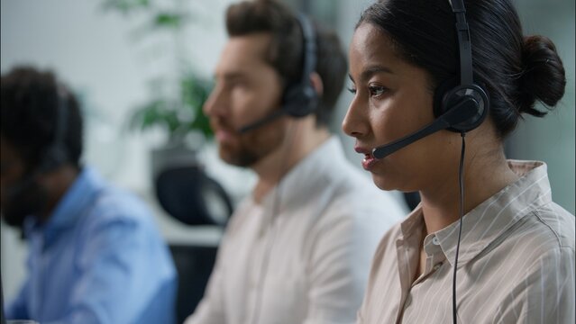 Close up smiling multiethnic team group operators diverse callcenter workers headset microphone consulting customer online service sales Indian business woman Caucasian African assistant call center