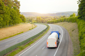 Road Fuel Tanker Truck with Blue Tank on Intercity European Highway With Two Lanes Among Rural...
