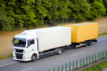 Twin-Trailer Freight Lorry with Yellow and White Containers in Motion