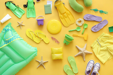Composition with beach toys and accessories on yellow background