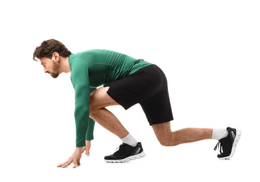 Sporty young man in crouch start position for marathon on white background
