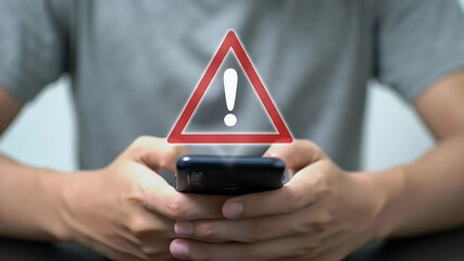 Man Holding Black Mobile Phone with Red Triangle Exclamation Mark Overlay Warning of a Problem Risk or Danger in a Security and Information Alert