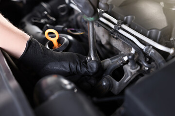 Auto parts. Professional mechanic with torque wrench fixing car indoors, closeup