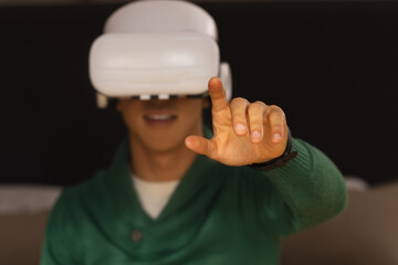 VR headset projecting holographic interface with hand reaching out on dark backdrop, copy space