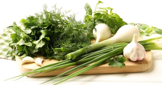 Different fresh herbs, green onions and garlic on white wooden table, closeup