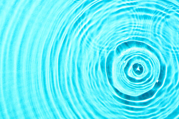 Clean water with drops on blue background, closeup