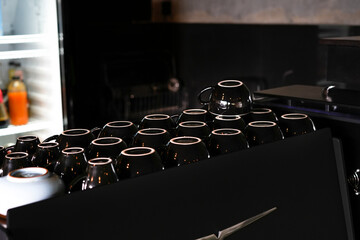 neatly arranged black coffee cups in a modern cafe interior