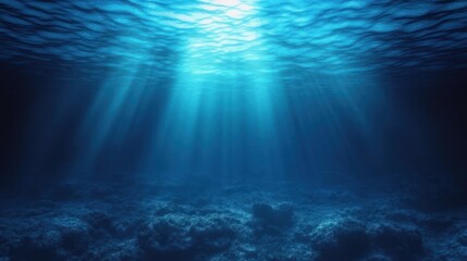Obraz premium Deep underwater scene with sunlight rays penetrating through the water surface illuminating the ocean floor with rocks and marine terrain