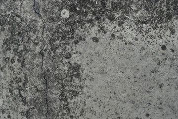 Detailed view of a gray concrete surface showcasing cracks and weathered textures, providing a raw, industrial feel. Ideal for backgrounds, construction themes, or conceptual