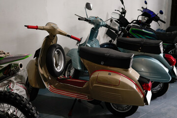 vintage scooters and motorbikes displayed in a garage setting