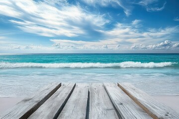 Obraz premium weathered wooden dock extending towards calm turquoise ocean under a bright blue sky with wispy white clouds