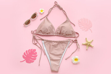 Composition with stylish swimsuit and paper tropical leaves on pink background, closeup