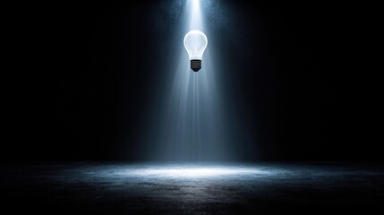Illuminated light bulb in spotlight.