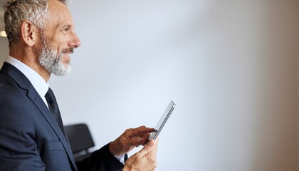 Smiling mature Indian ceo using tablet device at corporate workplace. Senior business manager dreaming. Copy space.