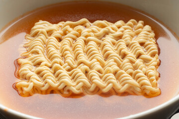 Raw instant noodles soaked in spicy soup