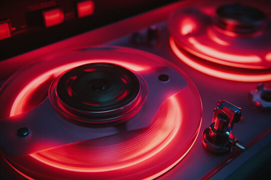 Record player spins vinyl in vibrant red lighting at a music studio session for a modern sound experience