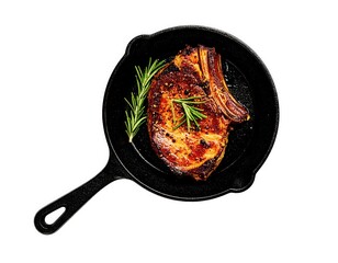 Grilled pork chop in cast iron skillet with rosemary High angle close up view