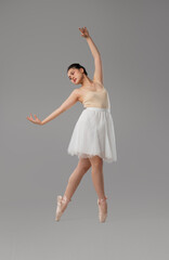 A young ballerina poses gracefully in a light tutu against a neutral backdrop Classical ballet