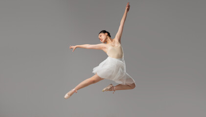 Ballet Dancer in Mid-Air: Graceful leap Light-toned leotard and white skirt Studio setting Elegant...